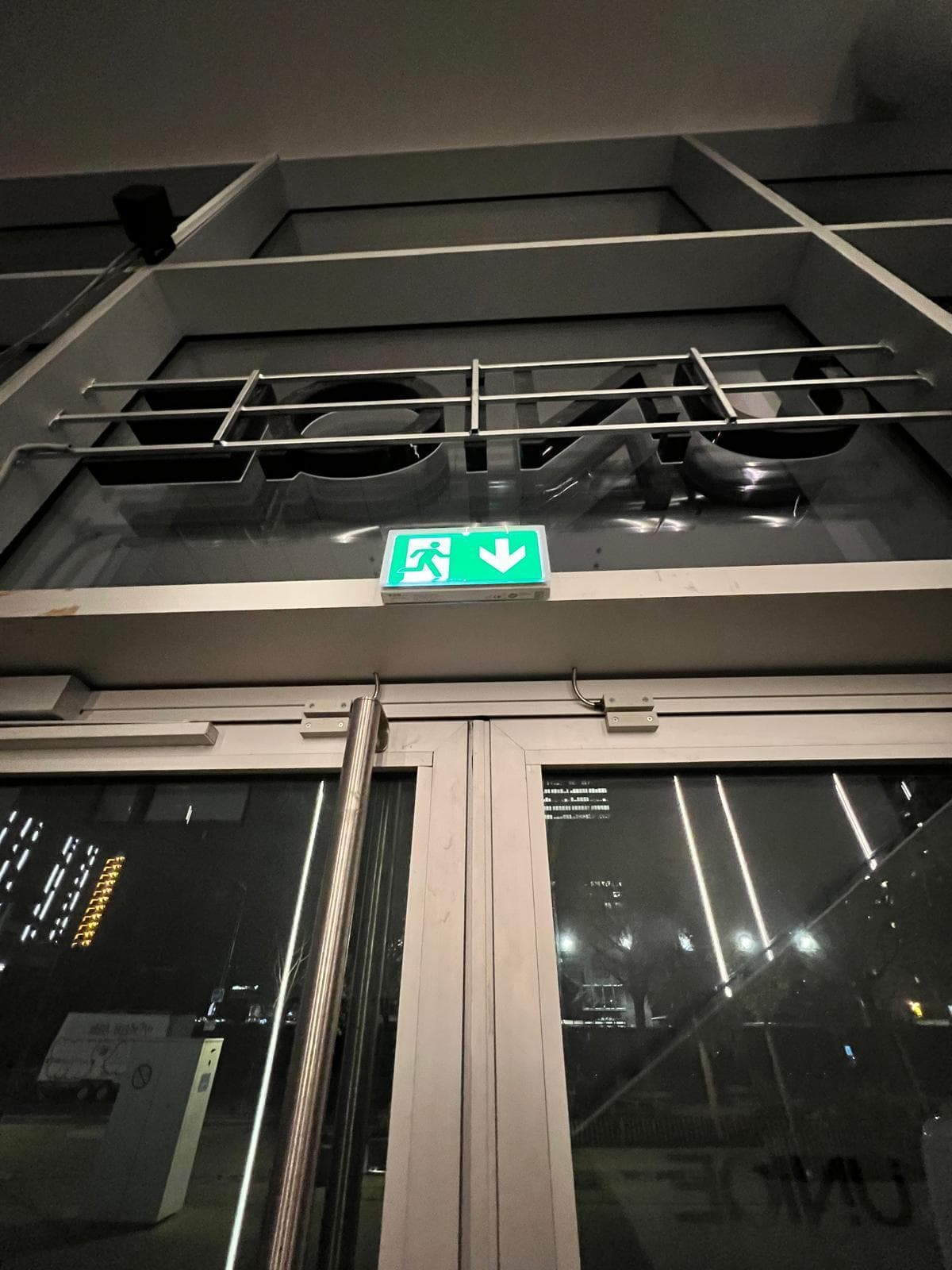 Entrée vitrée de la salle de sport avec bloc d'éclairage de sécurité (BAES)
