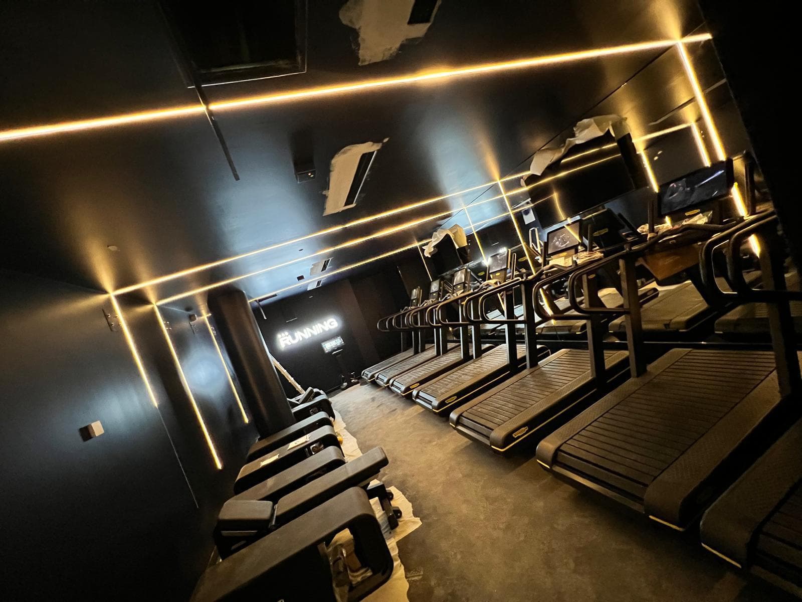 Éclairage LED linéaire de la salle cardio, vue sur les tapis de course
