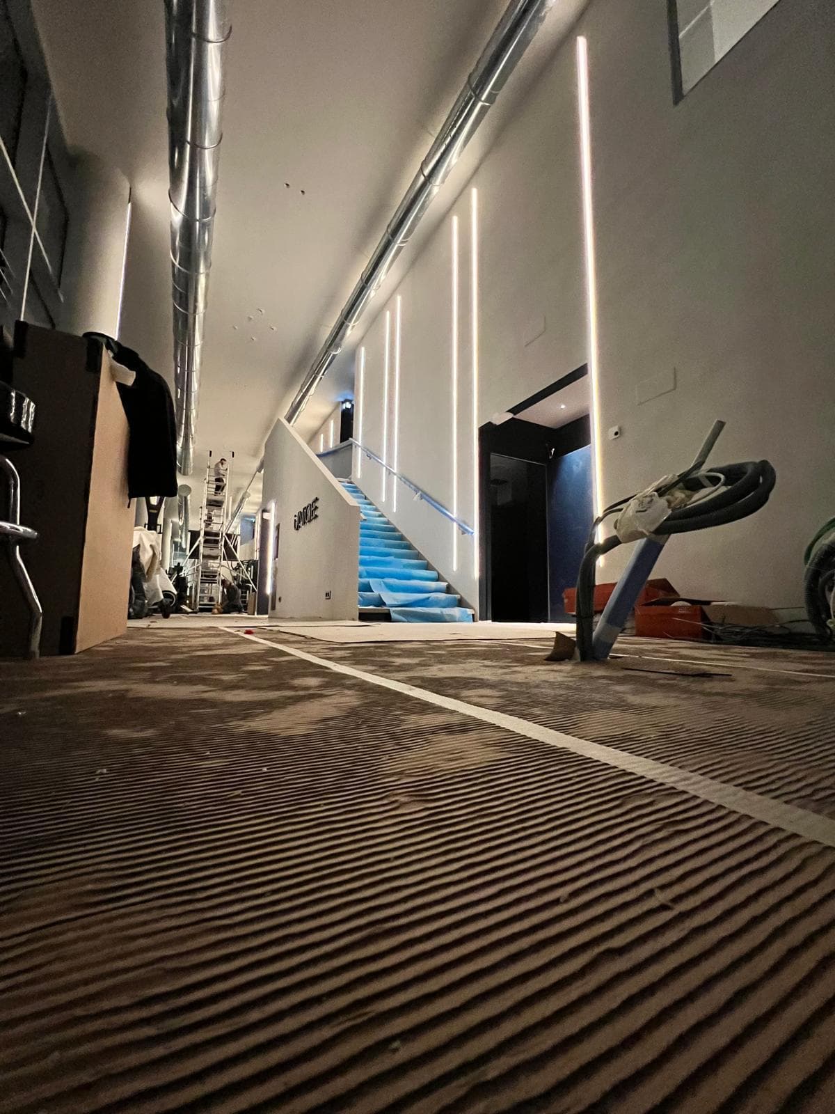 Circulation avec profilés LED verticaux et escalier aux marches éclairées