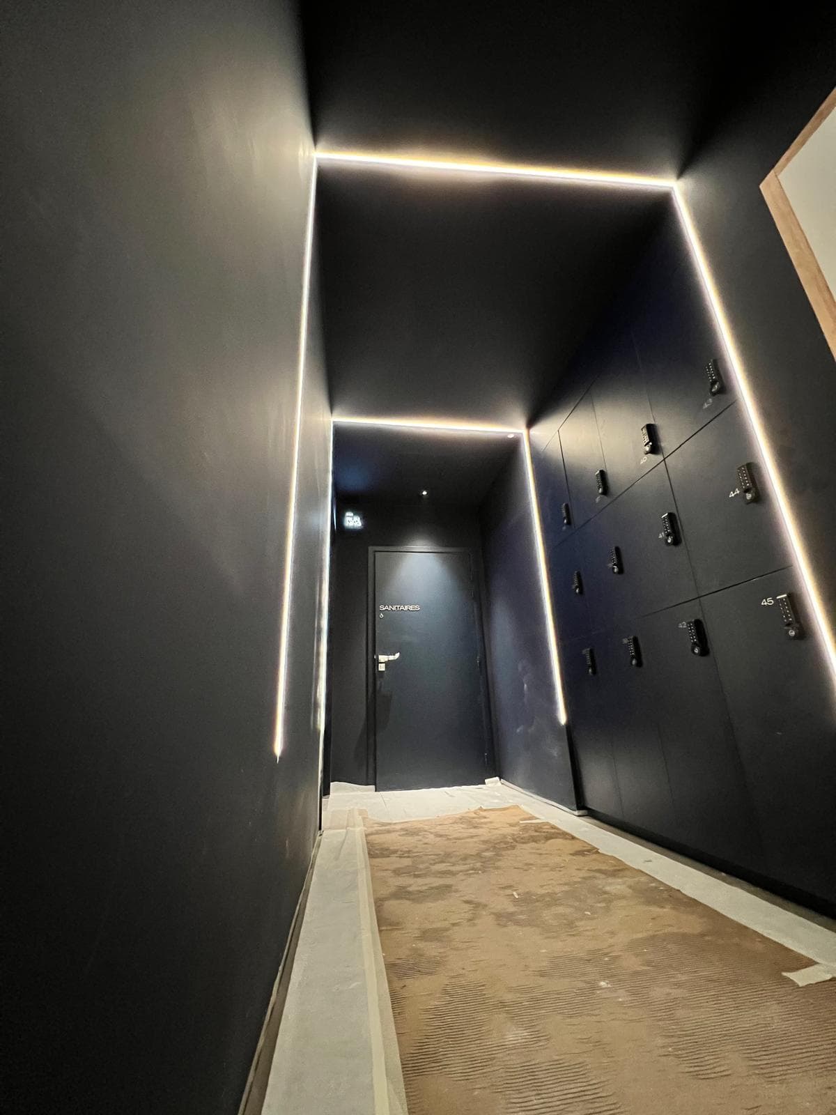 Couloir des vestiaires : lignes LED au plafond et en paroi