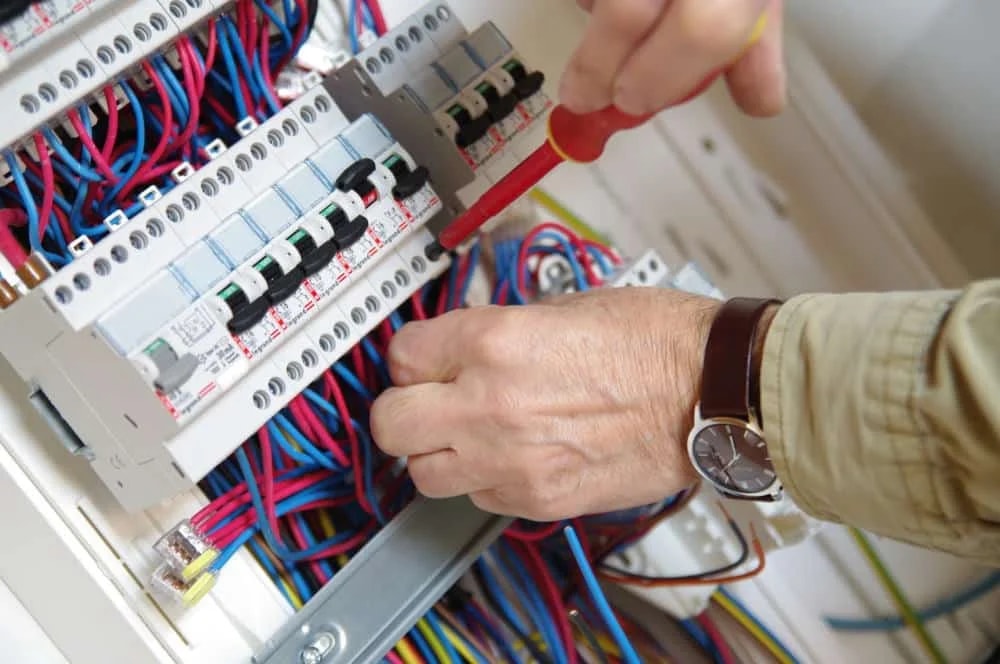 Électricien professionnel au travail sur un tableau électrique